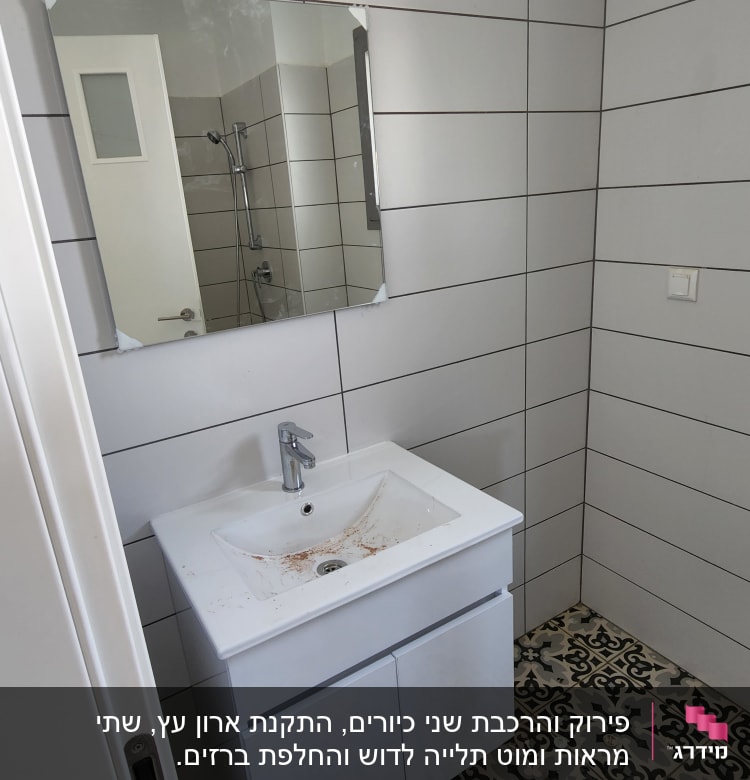 כיור עם ברז ומראה בחדר אמבטיה